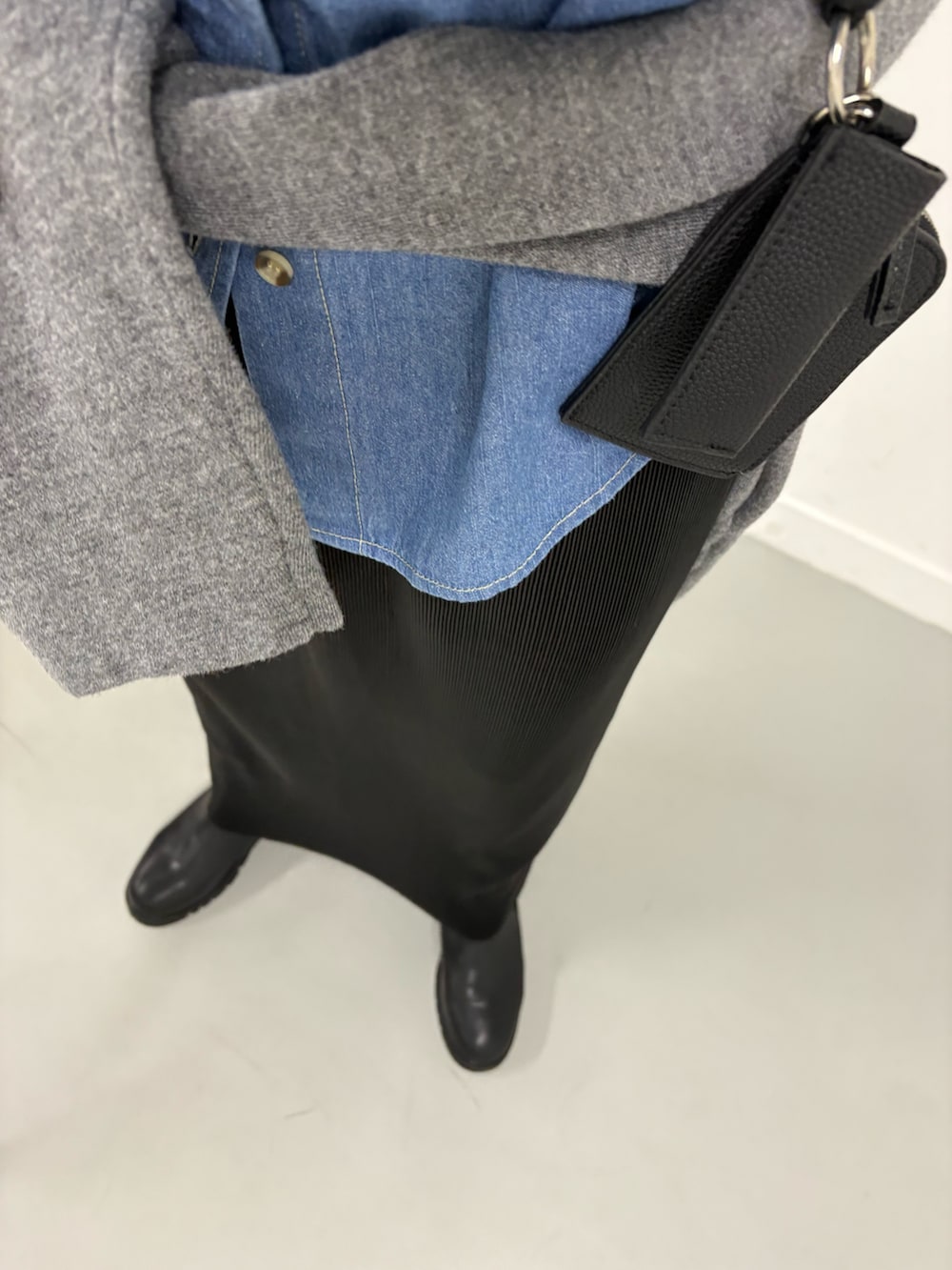 ブラック系のブーツ、ブルー系のシャツ/ブラウス、ブラック系のスカートを着用したレディースの秋コーディネートの7枚目の写真