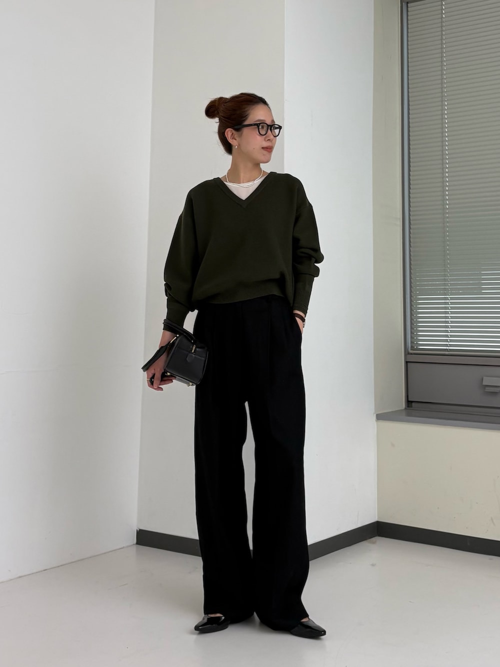 グリーン系のニット/セーター、ホワイト系のTシャツ/カットソー、ブラウン系のハンドバッグを着用したレディースの秋コーディネートの5枚目の写真