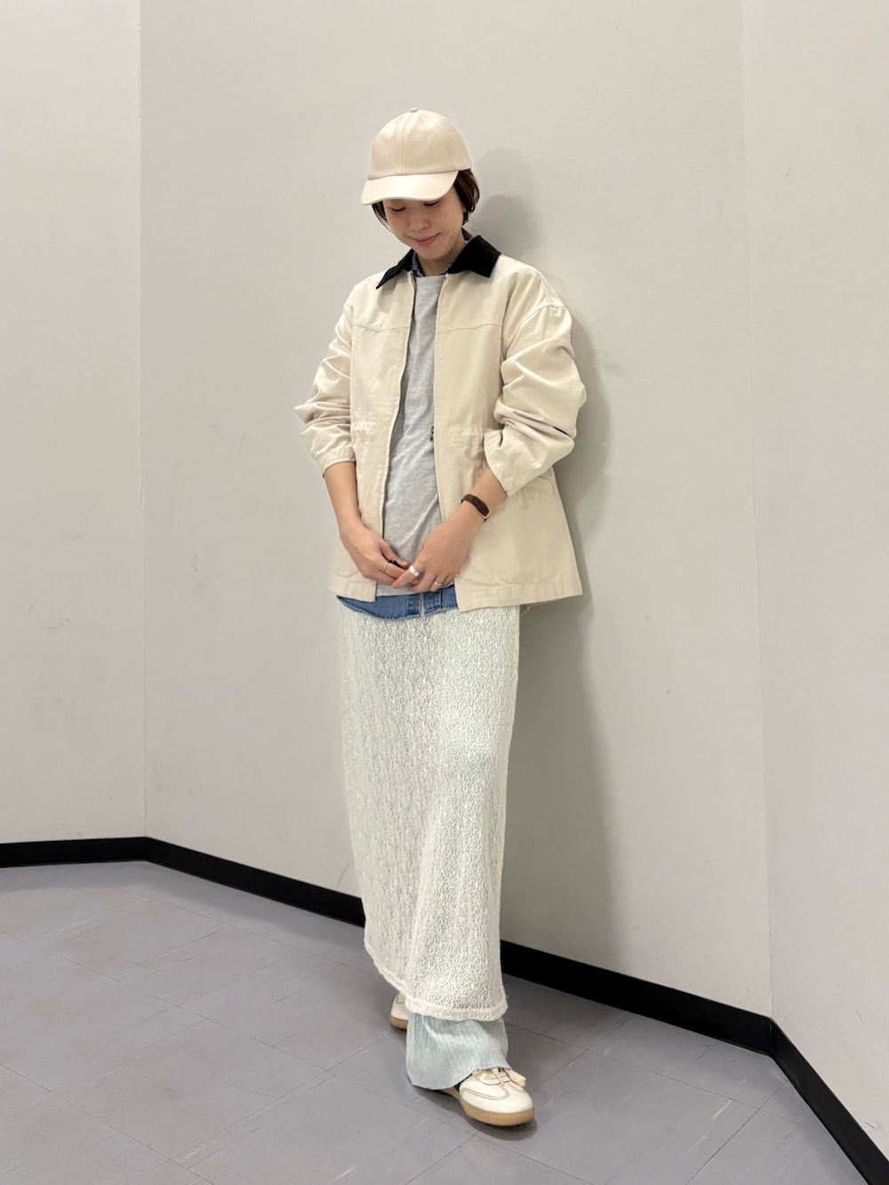 ベージュ系のカバーオール、ホワイト系のスカート、ホワイト系のスニーカーを着用したレディースの冬コーディネートの4枚目の写真