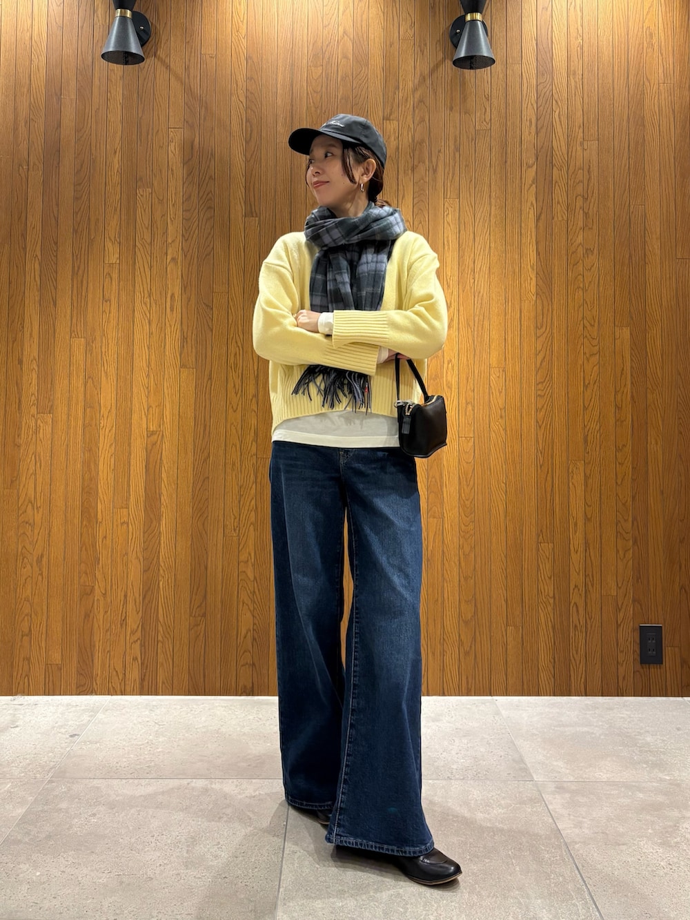 グレー系のその他アウター、イエロー系のニット/セーター、ブルー系のデニムパンツを着用したレディースの冬コーディネートの6枚目の写真