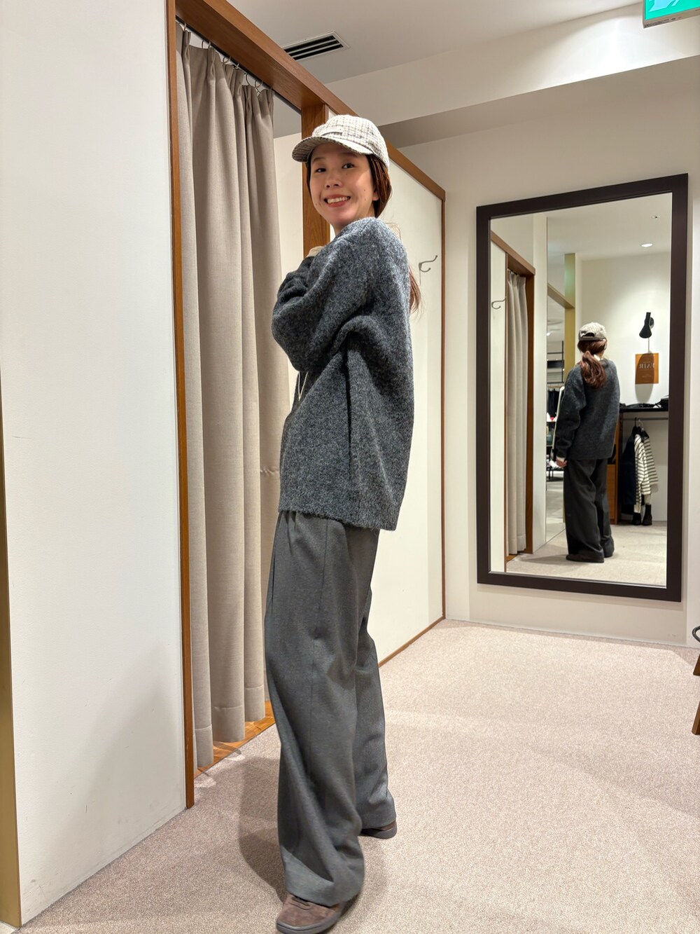 ブラック系のチェスターコート、グレー系のその他パンツ、ブラック系のハンドバッグを着用したレディースの冬コーディネートの6枚目の写真
