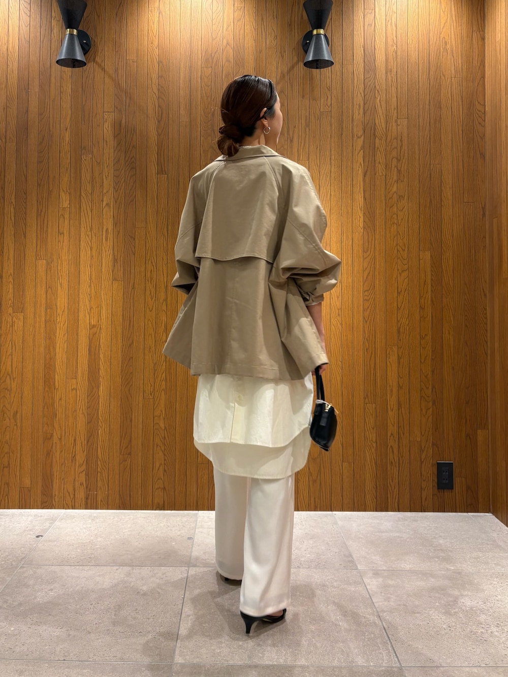 ベージュ系のトレンチコート、イエロー系のニット/セーター、ホワイト系のその他パンツを着用したレディースの春コーディネートの3枚目の写真