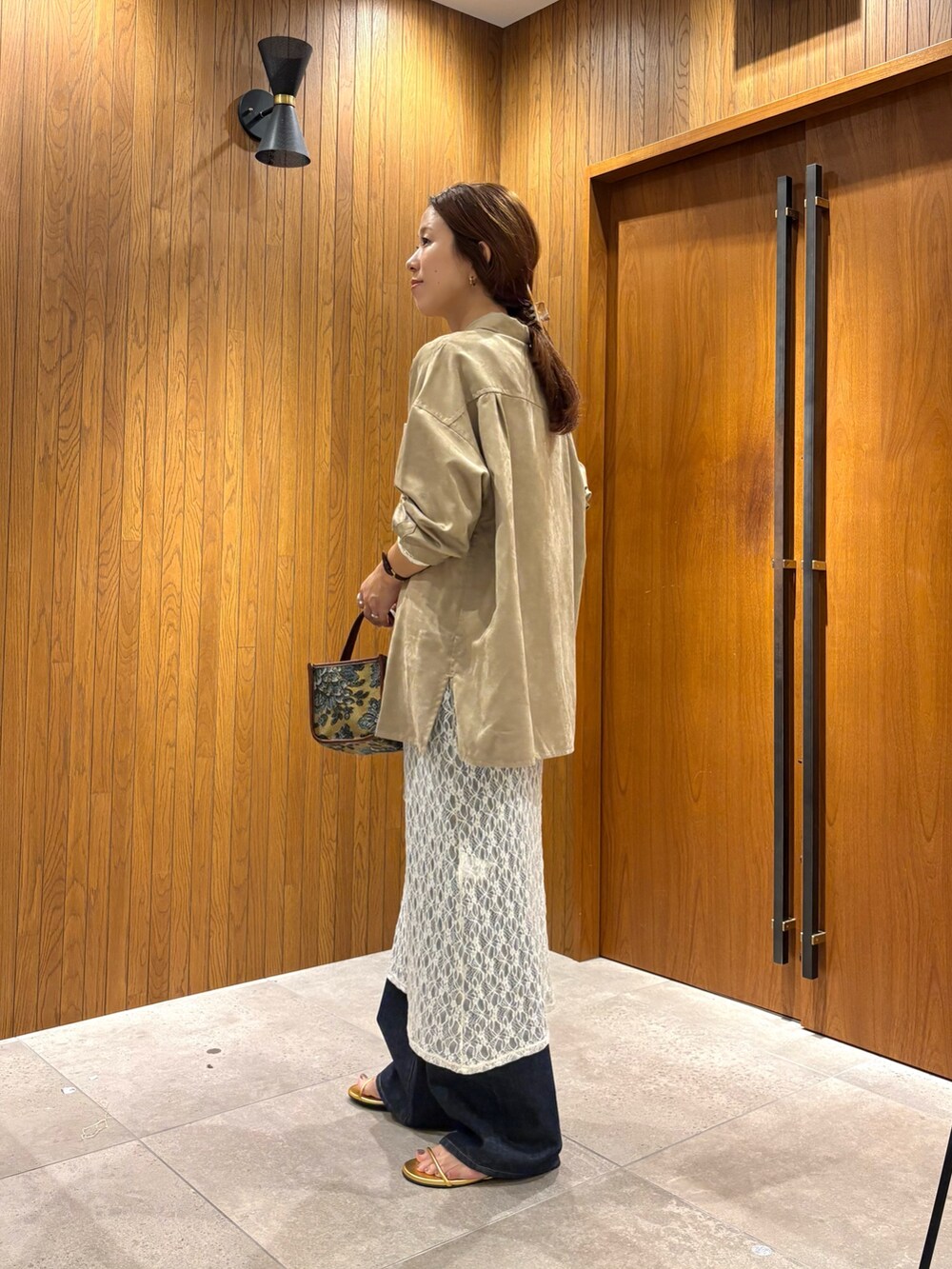 ホワイト系のワンピース、ベージュ系のシャツ/ブラウス、ゴールド系のサンダルを着用したレディースの夏コーディネートの2枚目の写真