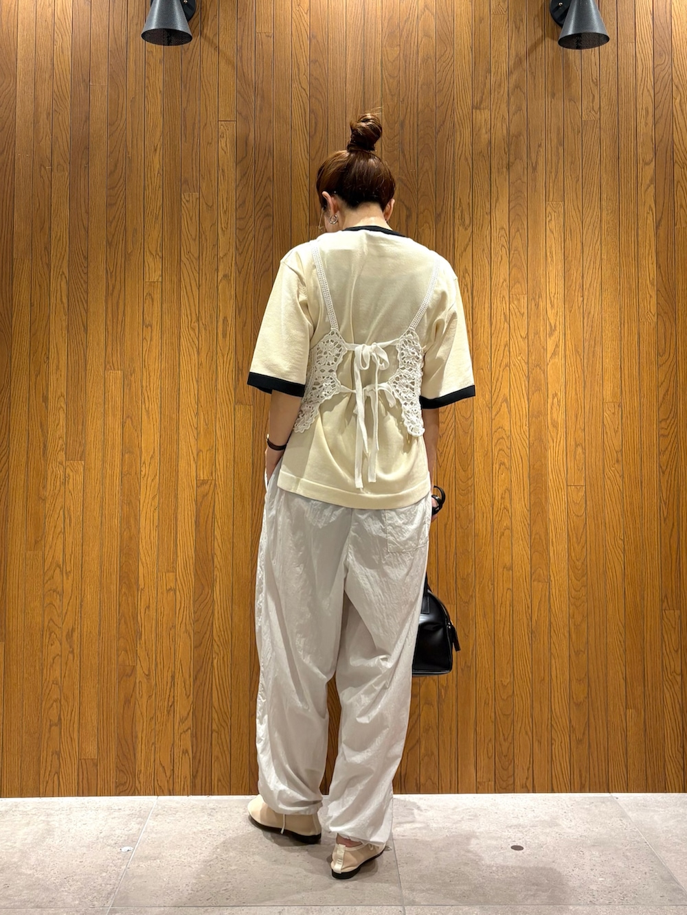 ホワイト系のニット/セーター、グレー系のその他パンツ、ブラック系のショルダーバッグを着用したレディースの夏コーディネートの4枚目の写真