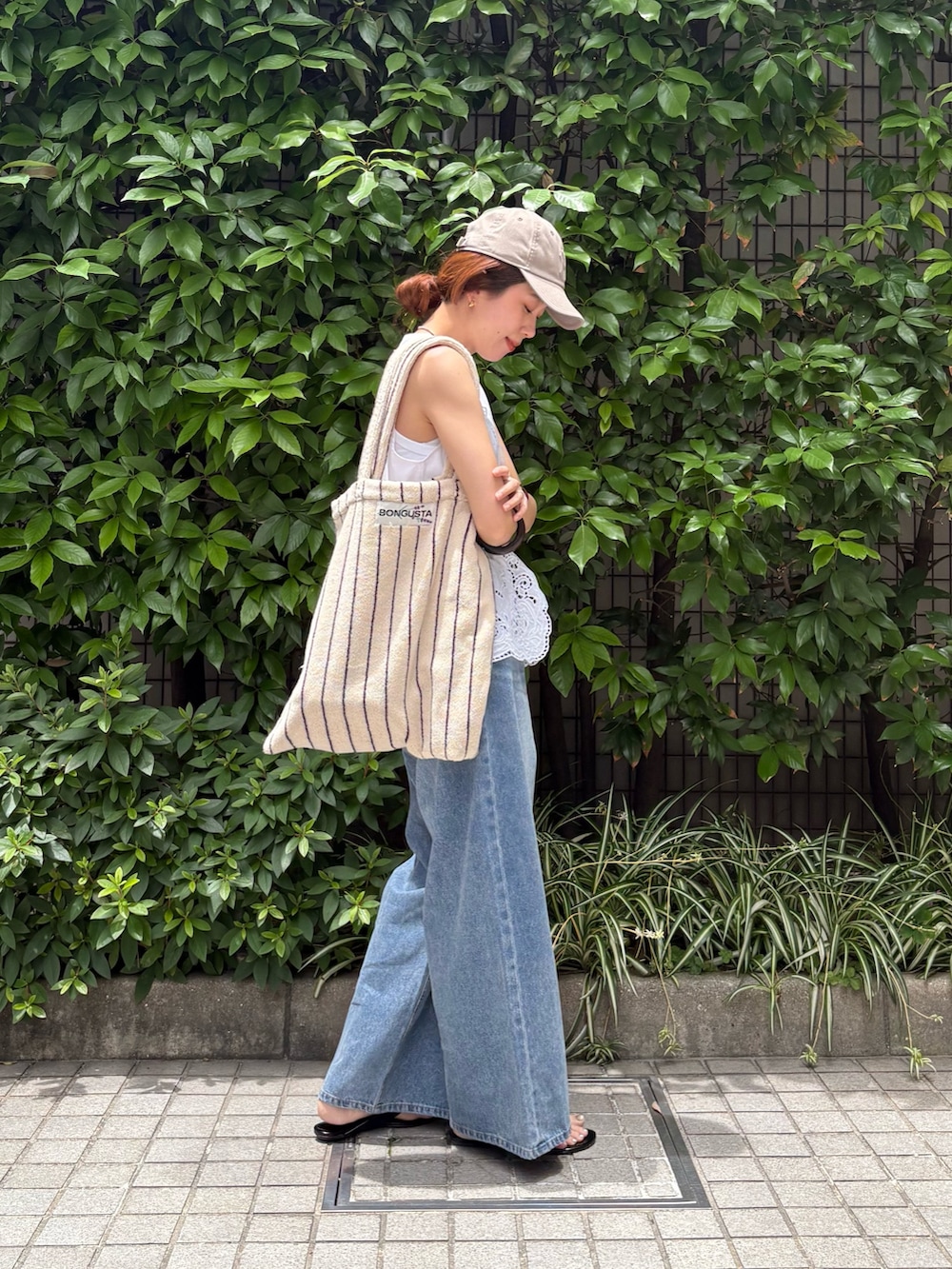 ホワイト系のシャツ/ブラウス、ブルー系のデニムパンツ、ホワイト系のトートバッグを着用したレディースの夏コーディネートの5枚目の写真