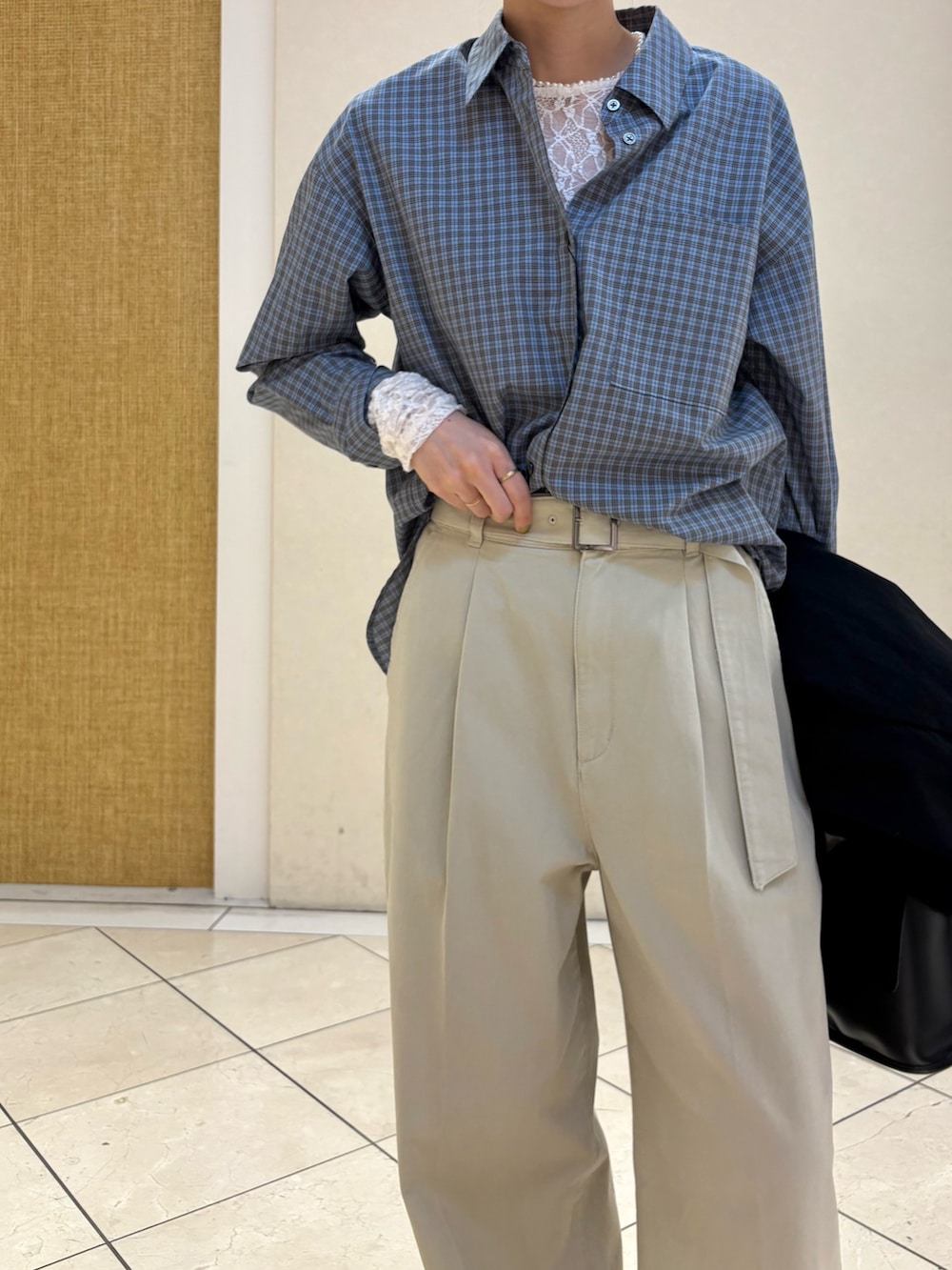 ブラック系のその他アウター、ベージュ系のその他パンツ、シルバー系のスニーカーを着用したレディースの春コーディネートの7枚目の写真