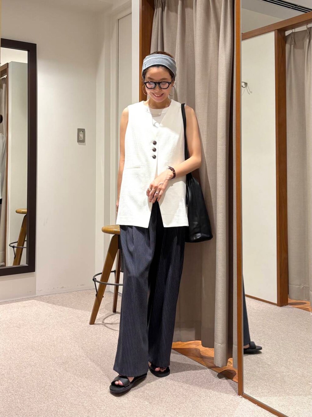 ブラック系のサンダル、ホワイト系のベスト、その他のその他パンツを着用したレディースの夏コーディネートの2枚目の写真