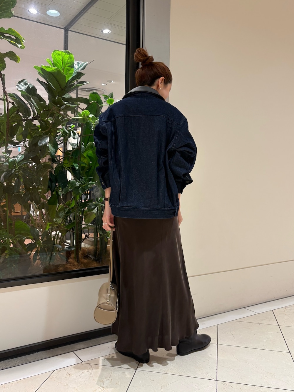 ホワイト系のシャツ/ブラウス、ブラウン系のスカート、ベージュ系のハンドバッグを着用したレディースの秋コーディネートの3枚目の写真