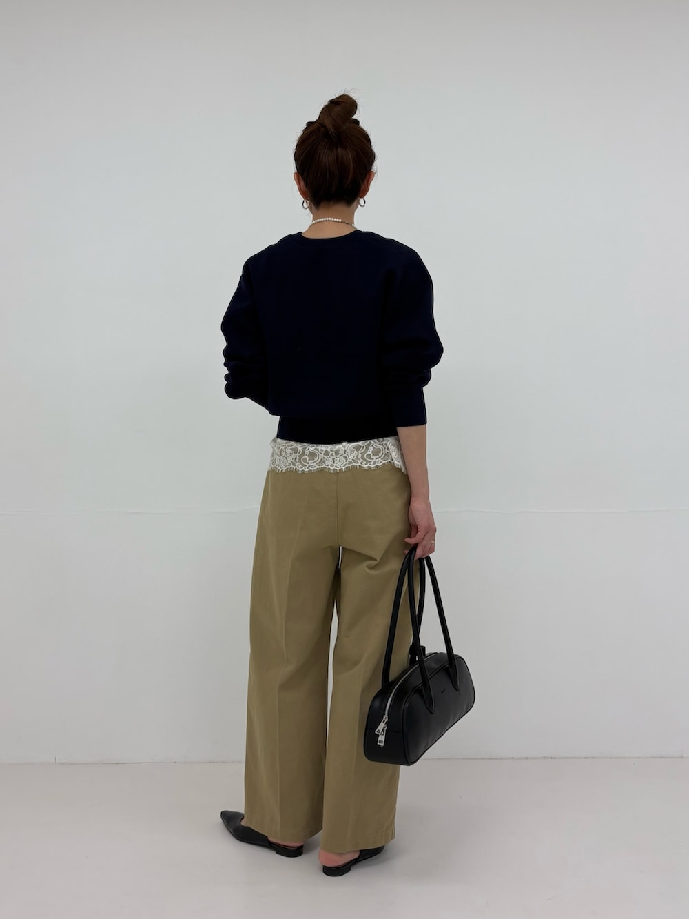 ブラック系のパンプス、ブルー系のニット/セーター、ベージュ系のその他パンツを着用したレディースの冬コーディネートの4枚目の写真