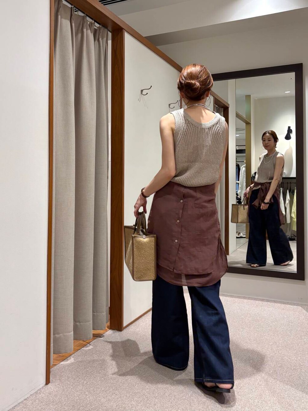 ブルー系のデニムパンツ、イエロー系のニット/セーター、ブラウン系のシャツ/ブラウスを着用したレディースの夏コーディネートの3枚目の写真