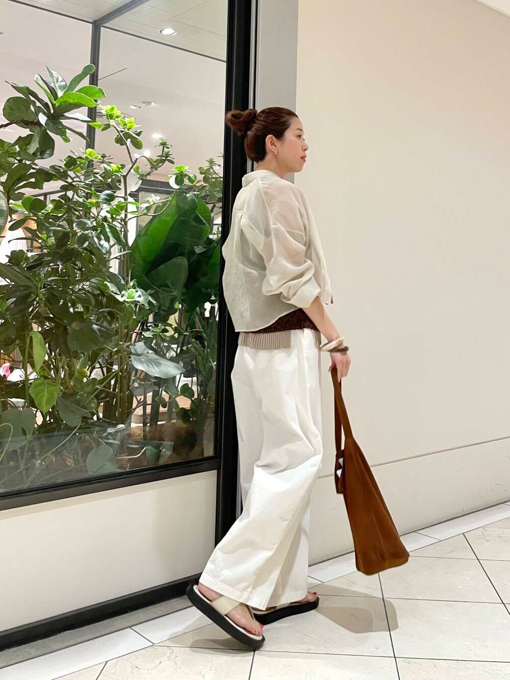 イエロー系のニット/セーター、ホワイト系のその他パンツ、ブラウン系のキャミソールを着用したレディースの春コーディネートの2枚目の写真