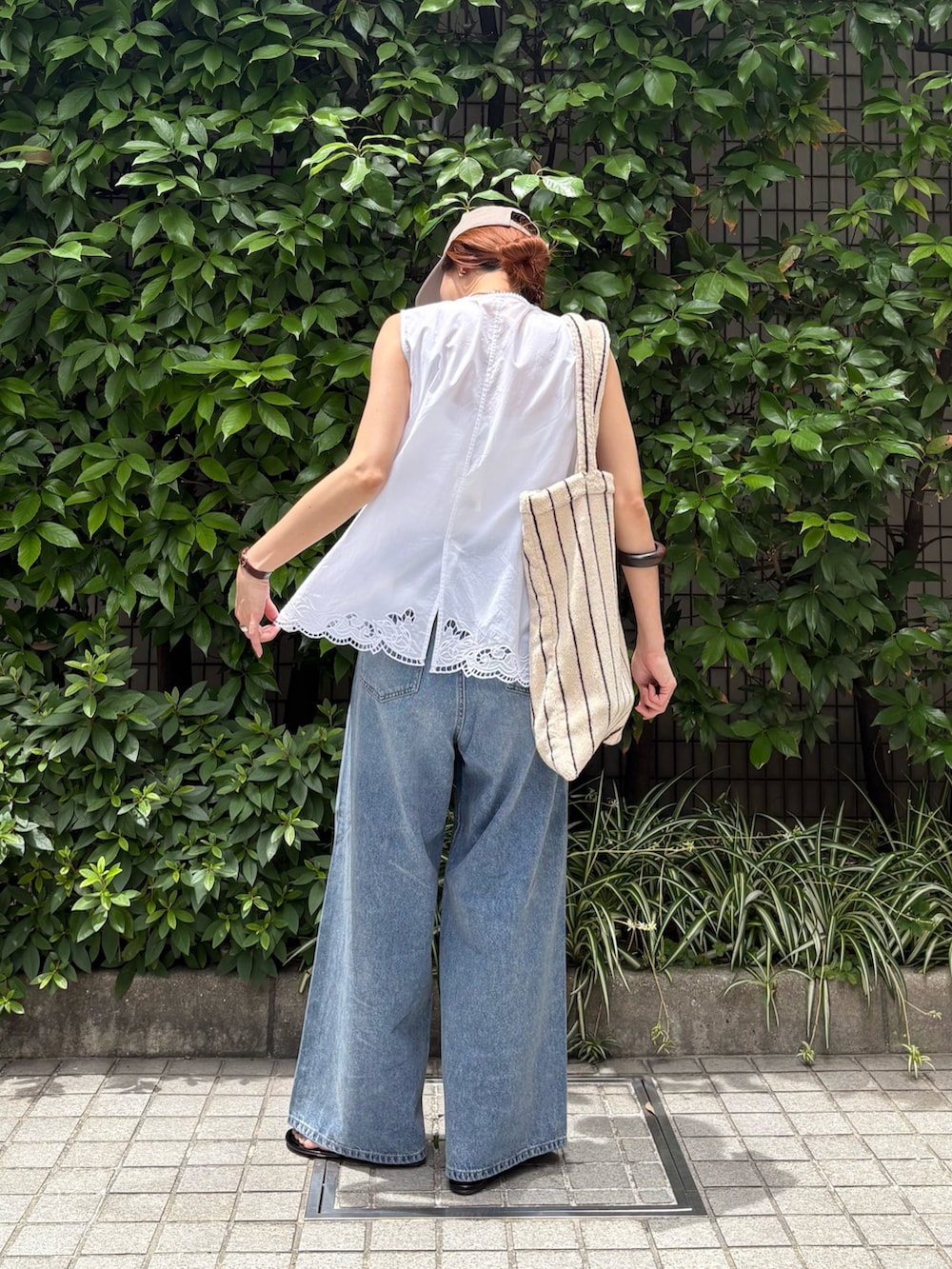 ホワイト系のシャツ/ブラウス、ブルー系のデニムパンツ、ホワイト系のトートバッグを着用したレディースの夏コーディネートの4枚目の写真