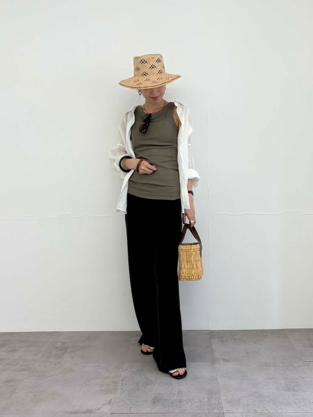 ブラウン系のかごバッグ、ホワイト系のシャツ/ブラウス、ブラック系のサンダルを着用したレディースの夏コーディネートの3枚目の写真