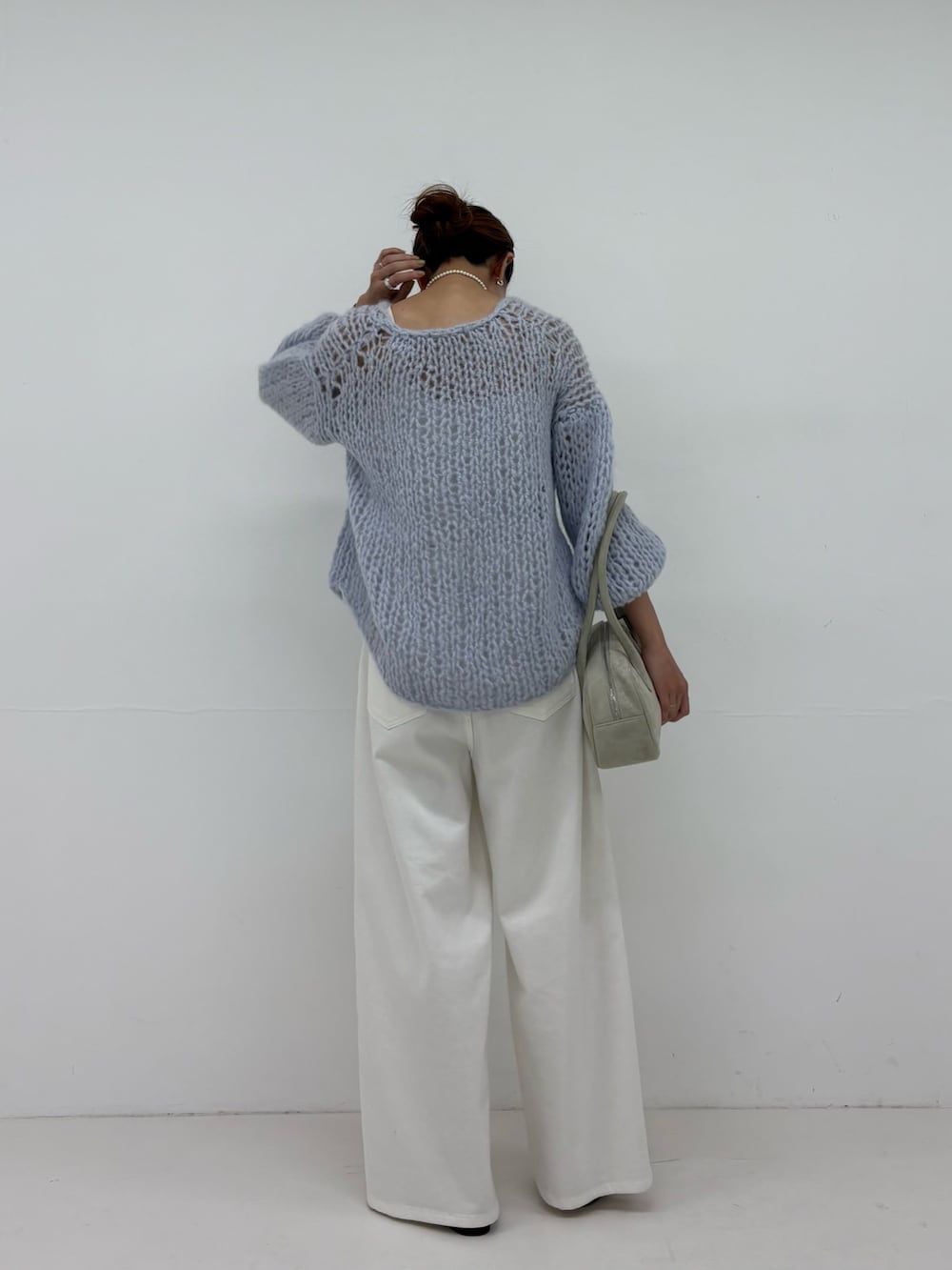 ホワイト系のショルダーバッグ、ホワイト系のデニムパンツ、シルバー系のパンプスを着用したレディースの夏コーディネートの3枚目の写真