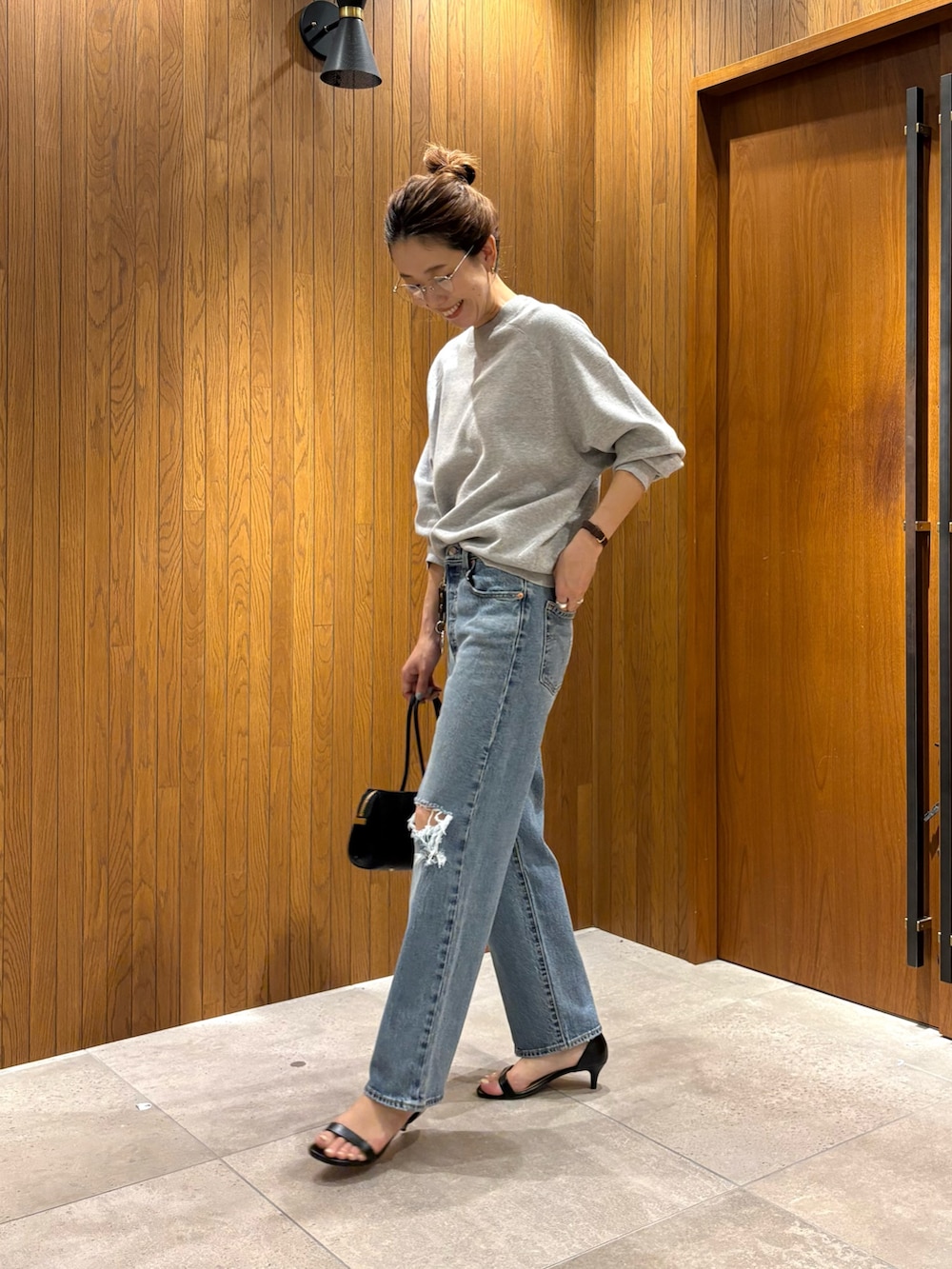 ブルー系のデニムパンツ、グレー系のニット/セーター、ブラック系のショルダーバッグを着用したレディースの秋コーディネートの5枚目の写真