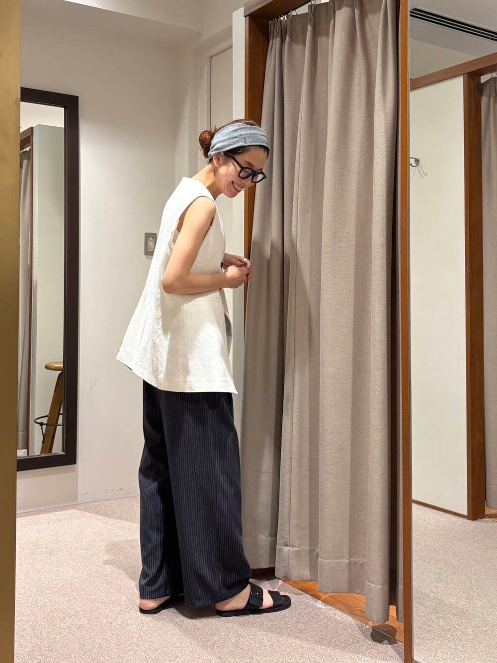 ブラック系のサンダル、ホワイト系のベスト、その他のその他パンツを着用したレディースの夏コーディネートの3枚目の写真