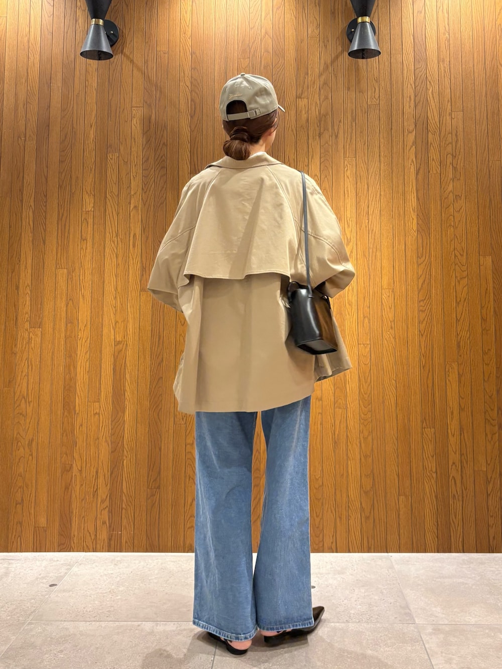 ベージュ系のトレンチコート、ホワイト系のシャツ/ブラウス、ブルー系のデニムパンツを着用したレディースの春コーディネートの3枚目の写真