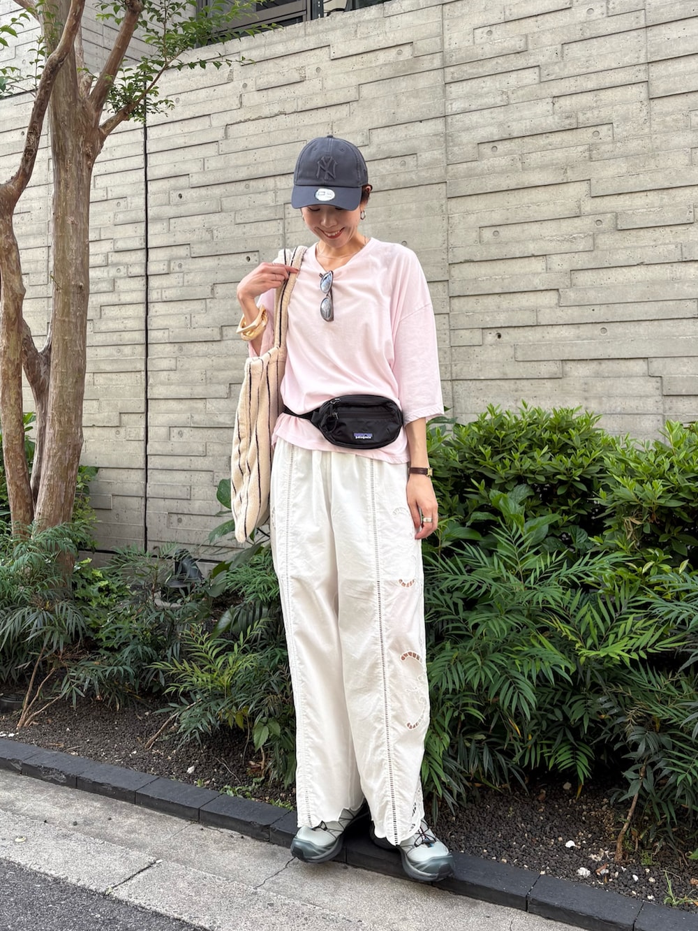 ピンク系のTシャツ/カットソー、グリーン系のスニーカー、ブラック系のボディバッグ/ウエストポーチを着用したレディースの春コーディネートの4枚目の写真