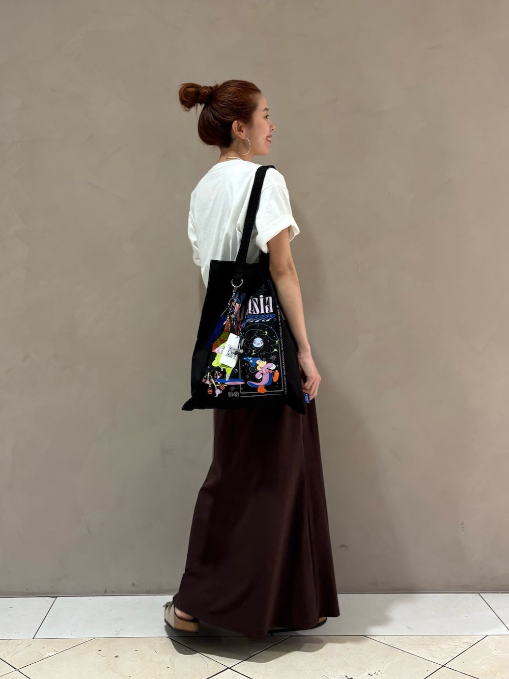 ブラウン系のスカート、その他のトートバッグ、ベージュ系のサンダルを着用したレディースの夏コーディネートの3枚目の写真