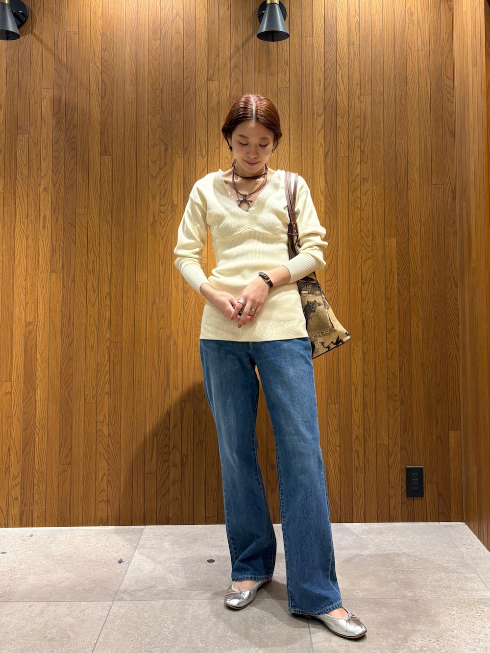 ホワイト系のニット/セーター、ブルー系のデニムパンツを着用したレディースの春コーディネートの6枚目の写真