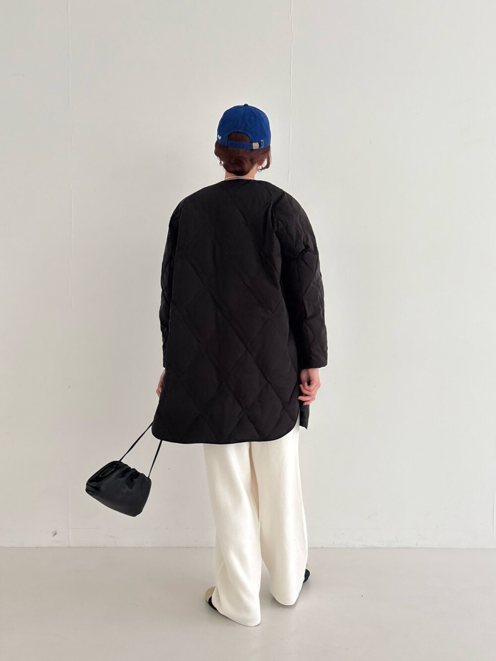 ベージュ系のスニーカー、ブラック系のダウンジャケット/コート、ピンク系のニット/セーターを着用したレディースの秋コーディネートの4枚目の写真