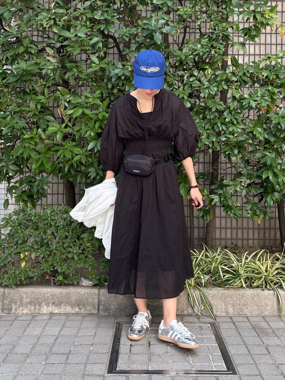 ホワイト系のブルゾン、ブラック系のワンピース、ブラック系のボディバッグ/ウエストポーチを着用したレディースの春コーディネートの5枚目の写真