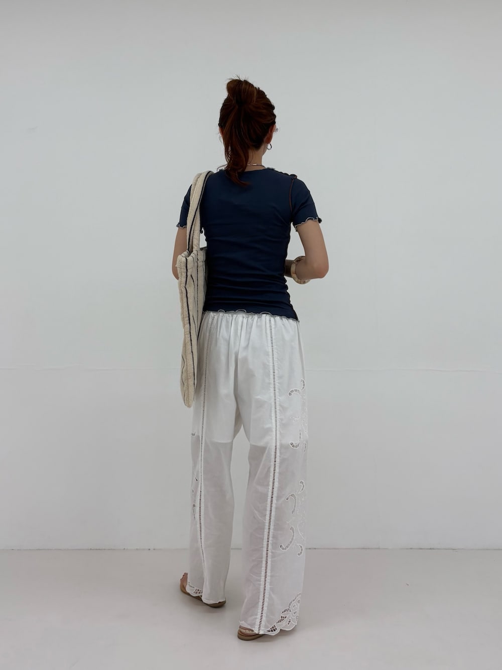 ブルー系のTシャツ/カットソー、ホワイト系のその他パンツ、ホワイト系のトートバッグを着用したレディースの春コーディネートの3枚目の写真