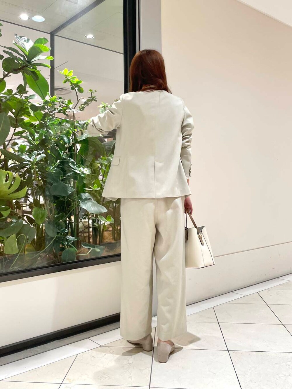 ホワイト系のトートバッグ、ベージュ系のパンプス、ホワイト系のシャツ/ブラウスを着用したレディースの冬コーディネートの4枚目の写真