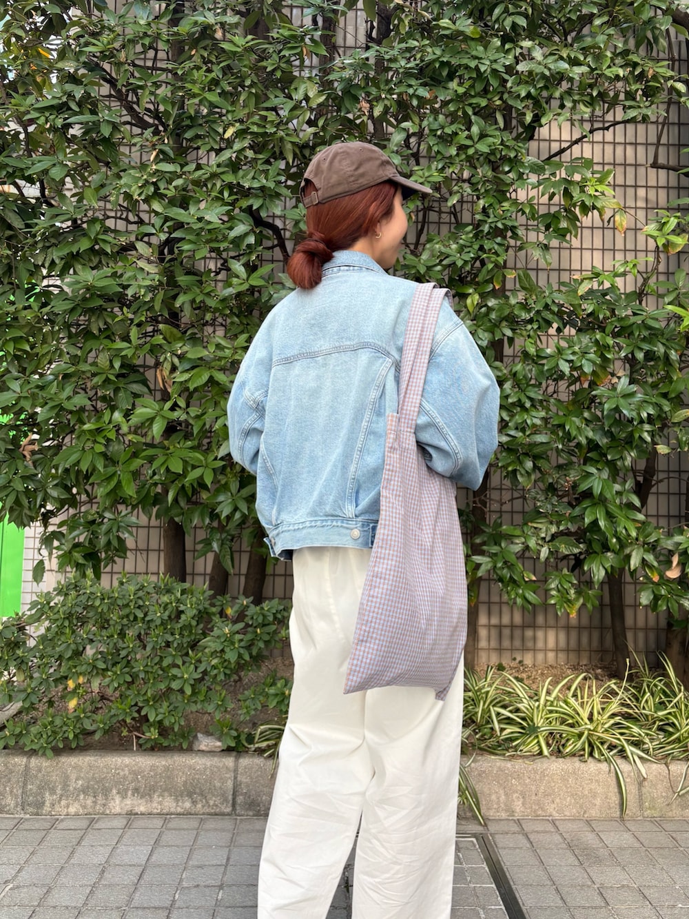 ホワイト系のニット/セーター、ブルー系のデニムジャケット、その他のトートバッグを着用したレディースの春コーディネートの6枚目の写真