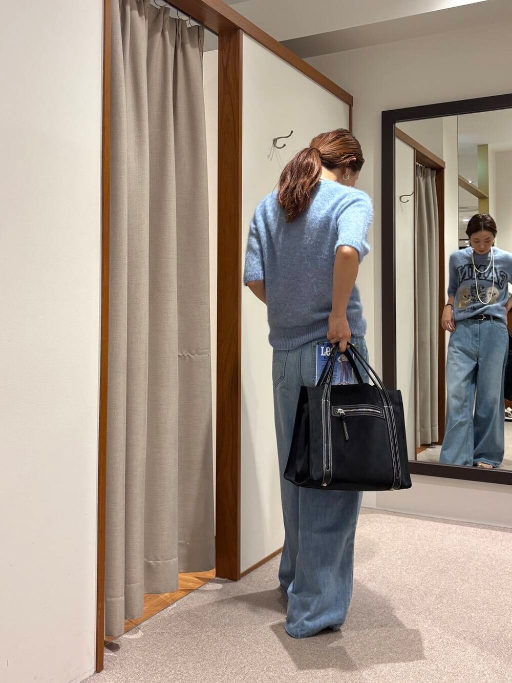 ブルー系のデニムパンツ、ブラック系のサンダルを着用したレディースの夏コーディネートの3枚目の写真