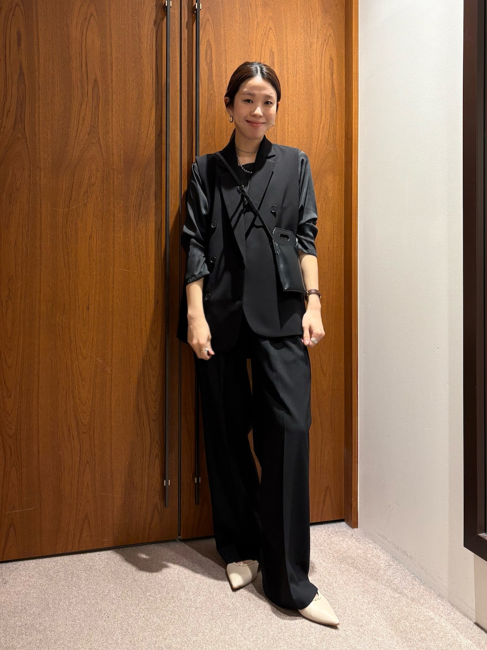 ベージュ系のトレンチコート、ブラック系のその他パンツ、ブラック系のその他アウターを着用したレディースの冬コーディネートの7枚目の写真