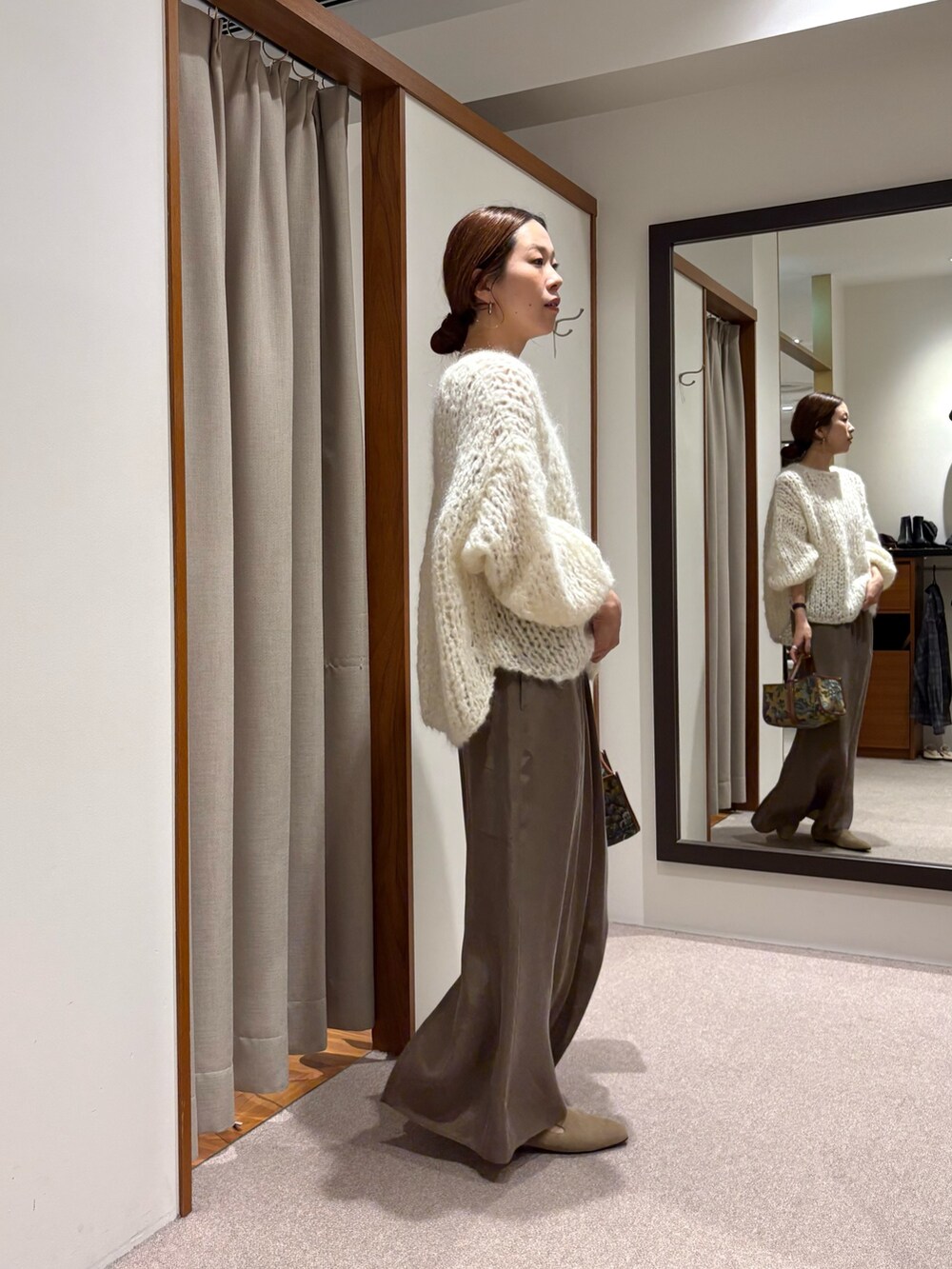 ホワイト系のニット/セーター、ブラック系のローファー、グリーン系のスカートを着用したレディースの秋コーディネートの2枚目の写真