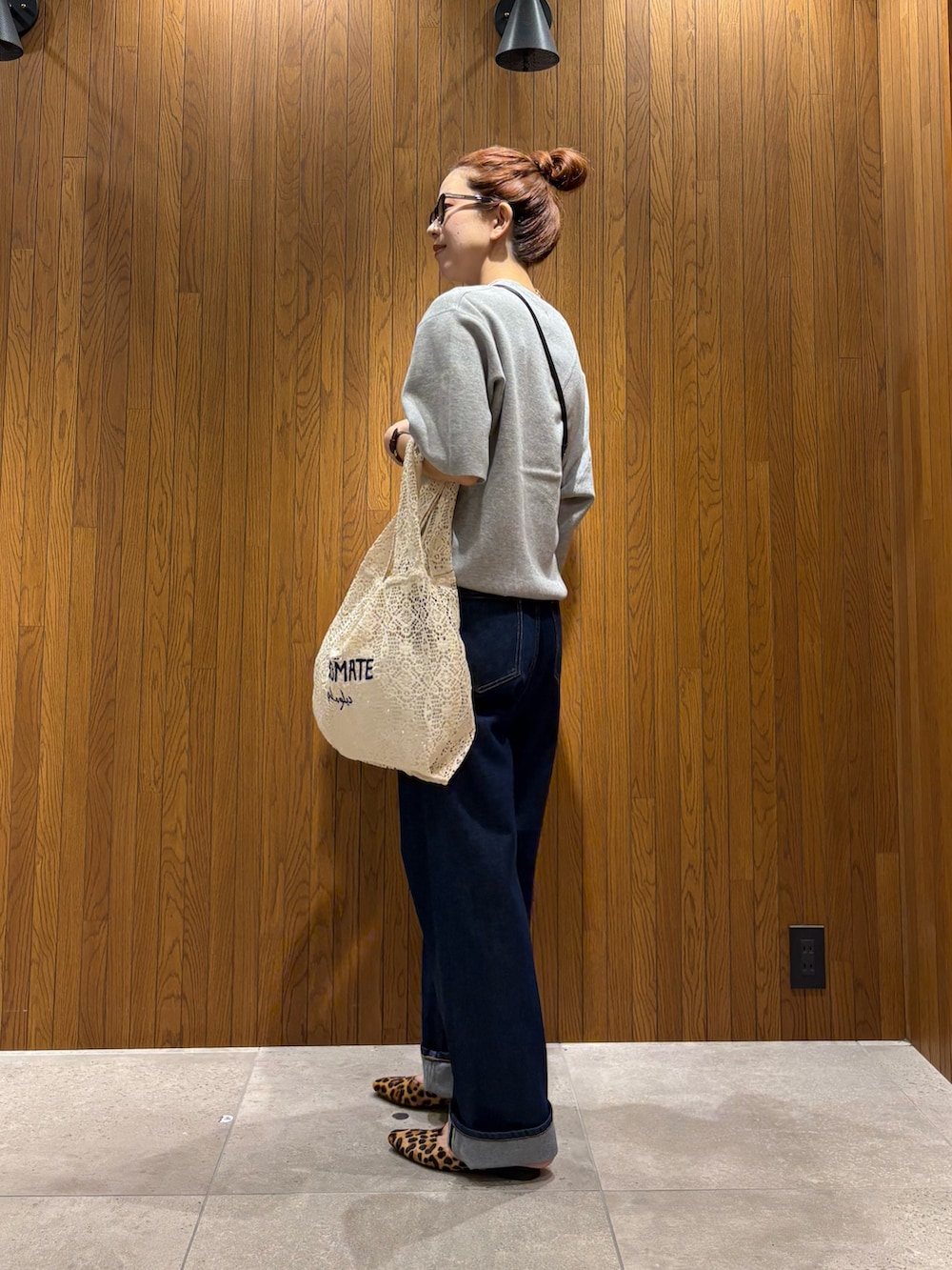 ホワイト系のハンドバッグ、ブルー系のデニムパンツ、ブラック系のショルダーバッグを着用したレディースの秋コーディネートの2枚目の写真