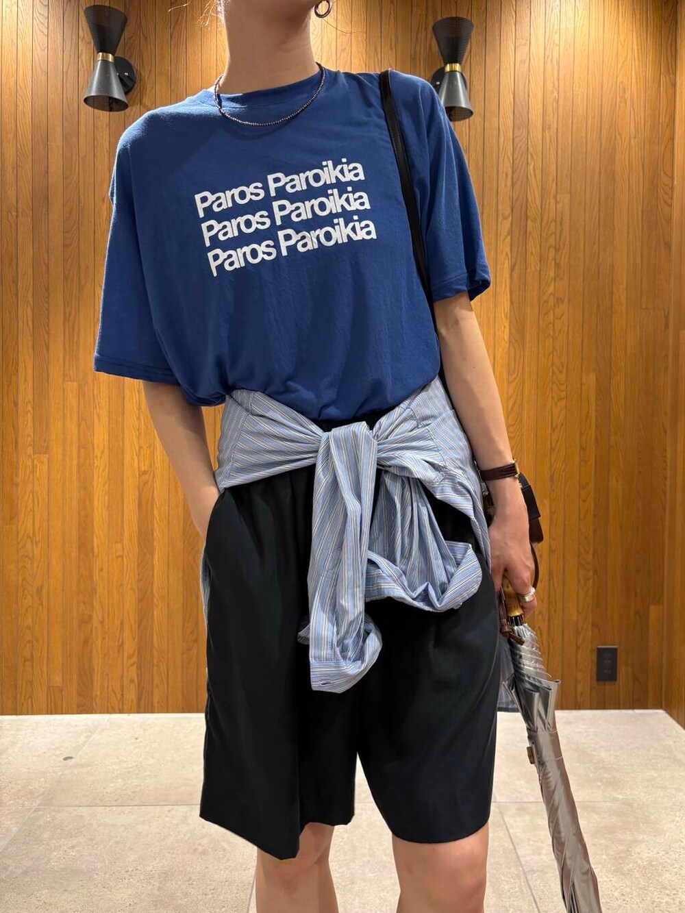 ブルー系のシャツ/ブラウス、シルバー系のスニーカー、ブラック系のショルダーバッグを着用したレディースの夏コーディネートの5枚目の写真