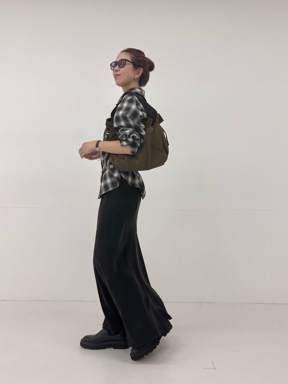 ブラック系のスカート、ブラウン系のショルダーバッグ、ブラック系のシャツ/ブラウスを着用したレディースの秋コーディネートの2枚目の写真