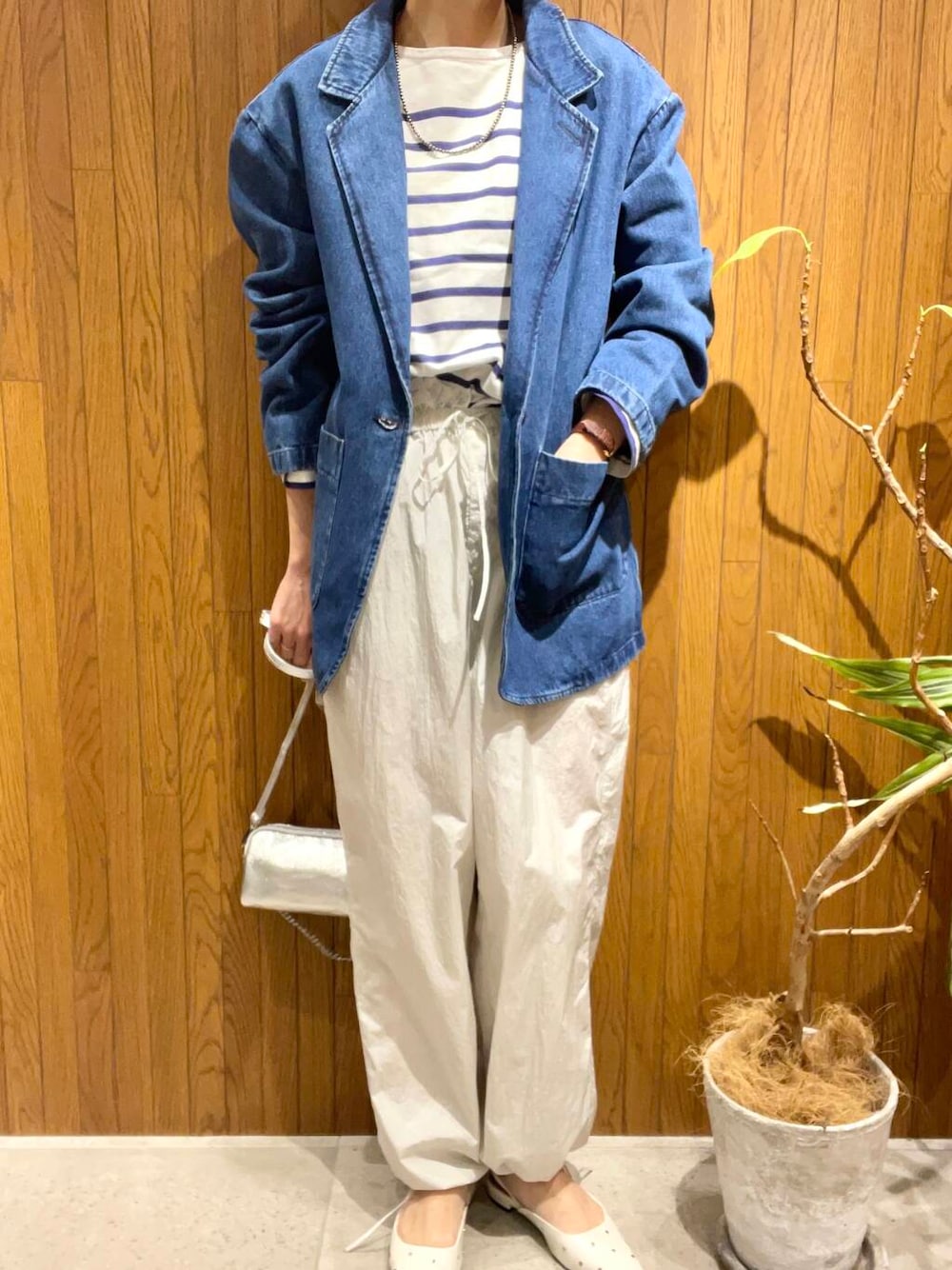 シルバー系のショルダーバッグ、ホワイト系のパンプス、ブルー系のデニムジャケットを着用したレディースの冬コーディネートの5枚目の写真