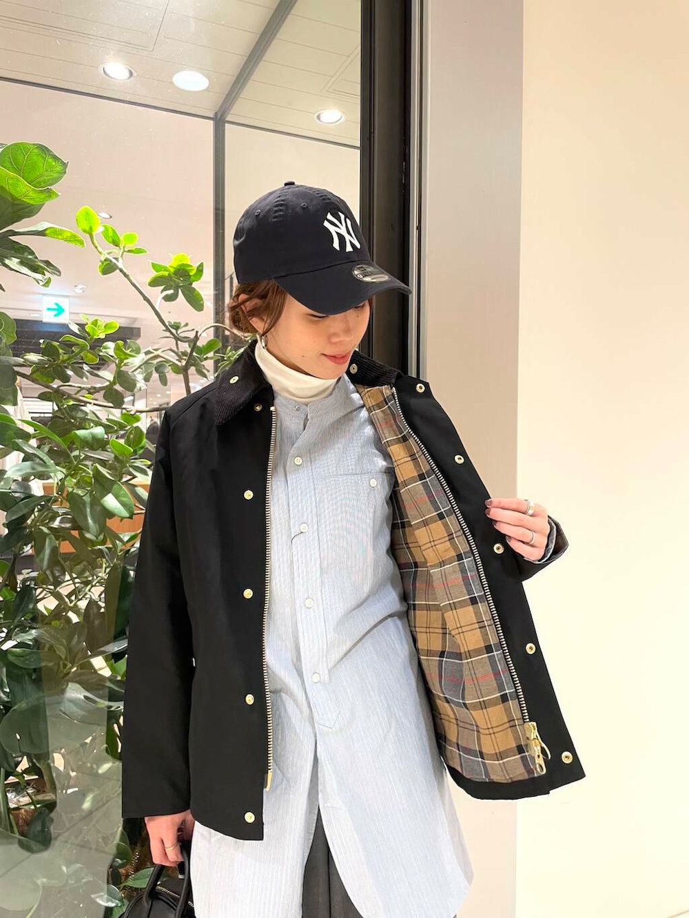 ブラック系のショルダーバッグ、ブルー系のTシャツ/カットソー、ホワイト系のスニーカーを着用したレディースの冬コーディネートの4枚目の写真