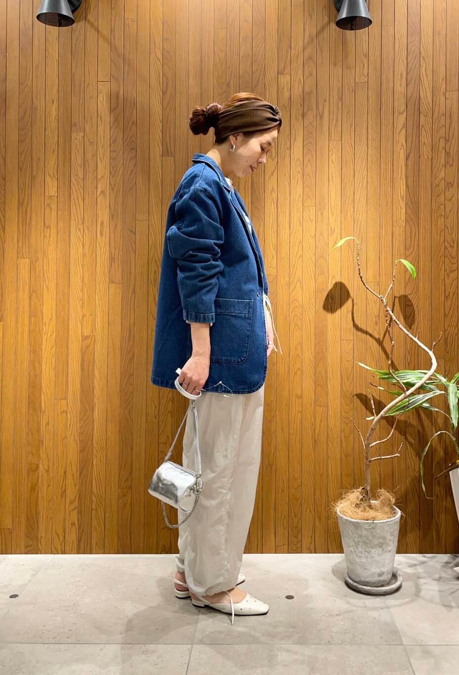 シルバー系のショルダーバッグ、ホワイト系のパンプス、ブルー系のデニムジャケットを着用したレディースの冬コーディネートの2枚目の写真