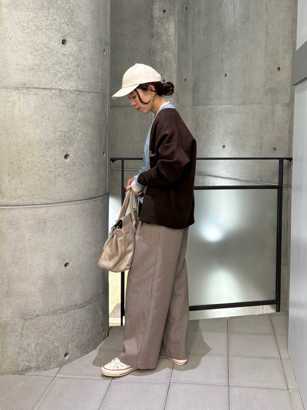 イエロー系のその他パンツ、ブルー系のTシャツ/カットソー、ベージュ系のハンドバッグを着用したレディースの秋コーディネートの2枚目の写真