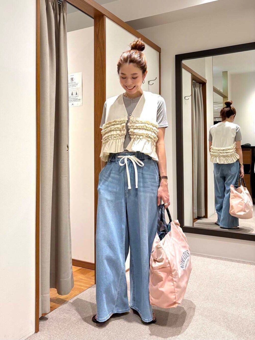 ピンク系のトートバッグ、ブルー系のデニムパンツ、ホワイト系のシャツ/ブラウスを着用したレディースの夏コーディネートの5枚目の写真