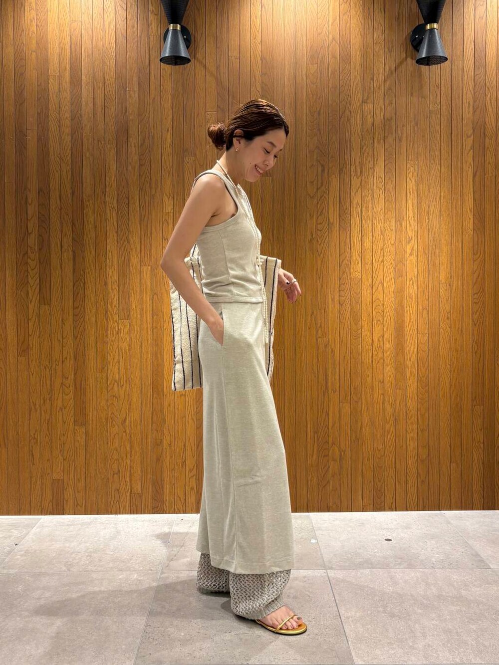 ゴールド系のサンダルを着用したレディースの夏コーディネートの3枚目の写真