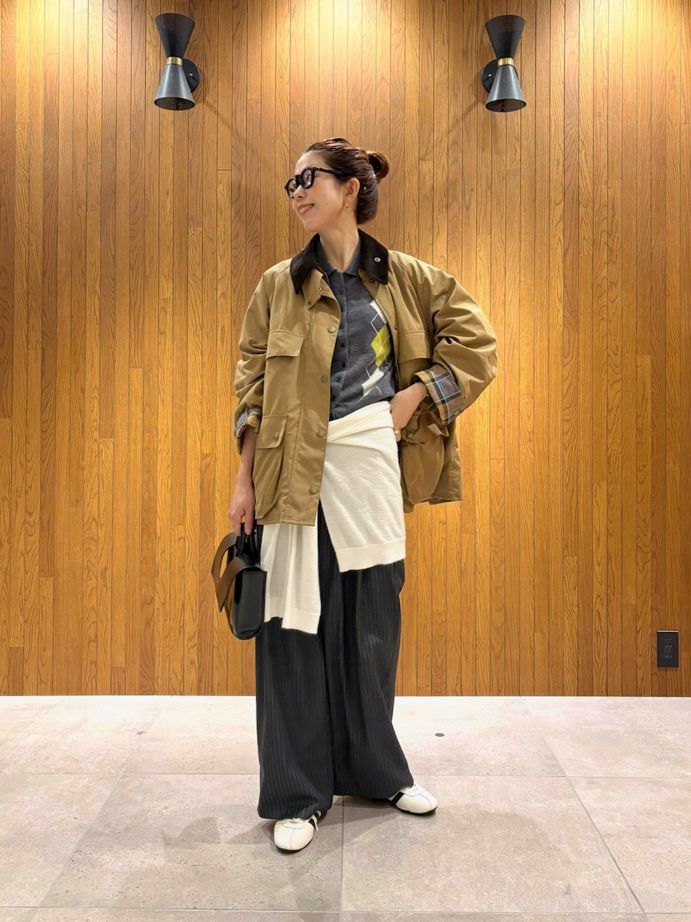 ホワイト系のスニーカー、ベージュ系のその他アウター、グレー系のニット/セーターを着用したレディースの秋コーディネートの2枚目の写真