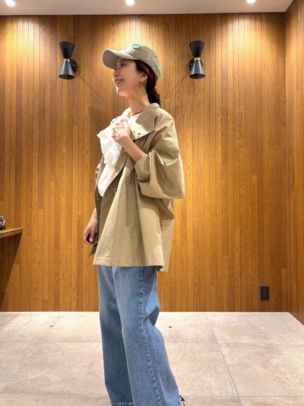 ベージュ系のトレンチコート、ホワイト系のシャツ/ブラウス、ブルー系のデニムパンツを着用したレディースの春コーディネートの5枚目の写真