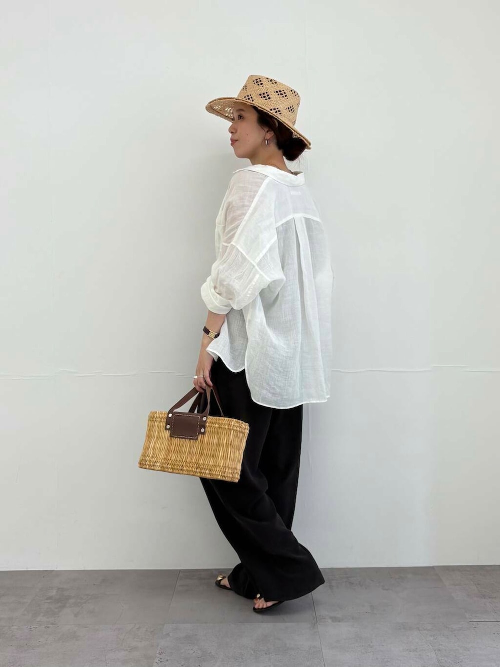 ブラウン系のかごバッグ、ホワイト系のシャツ/ブラウス、ブラック系のサンダルを着用したレディースの夏コーディネートの4枚目の写真