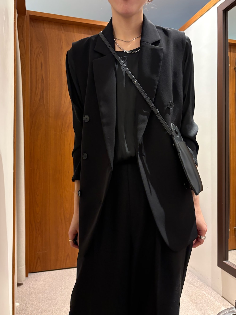 ベージュ系のトレンチコート、ブラック系のその他パンツ、ブラック系のその他アウターを着用したレディースの冬コーディネートの10枚目の写真