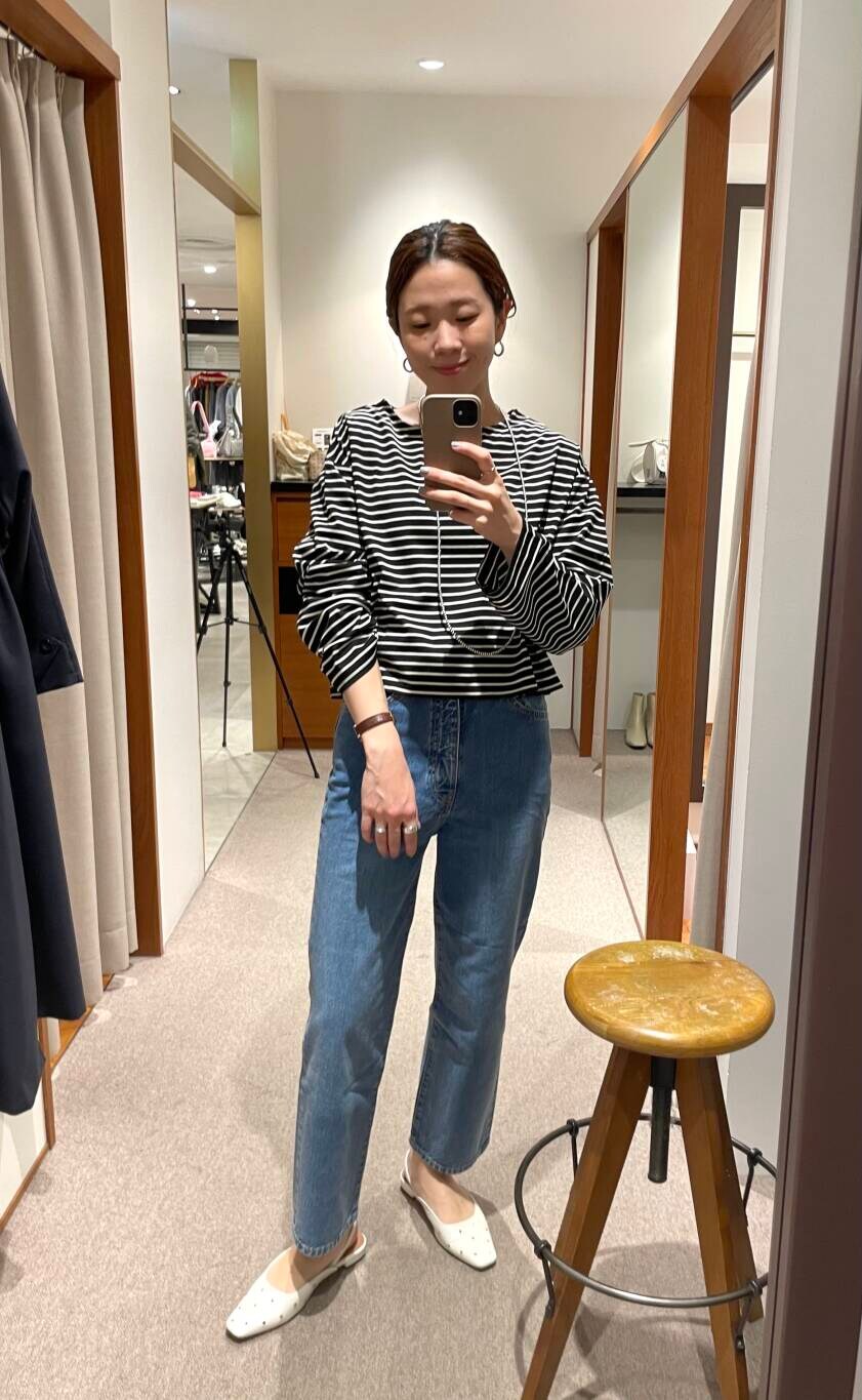 ブルー系のデニムパンツ、ブラック系のTシャツ/カットソー、ホワイト系のボストンバッグを着用したレディースの冬コーディネートの6枚目の写真