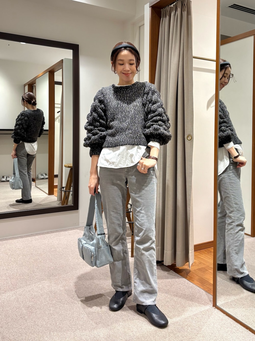 ブラック系のニット/セーター、グリーン系のショルダーバッグ、ブラック系のバレエシューズを着用したレディースの冬コーディネートの5枚目の写真