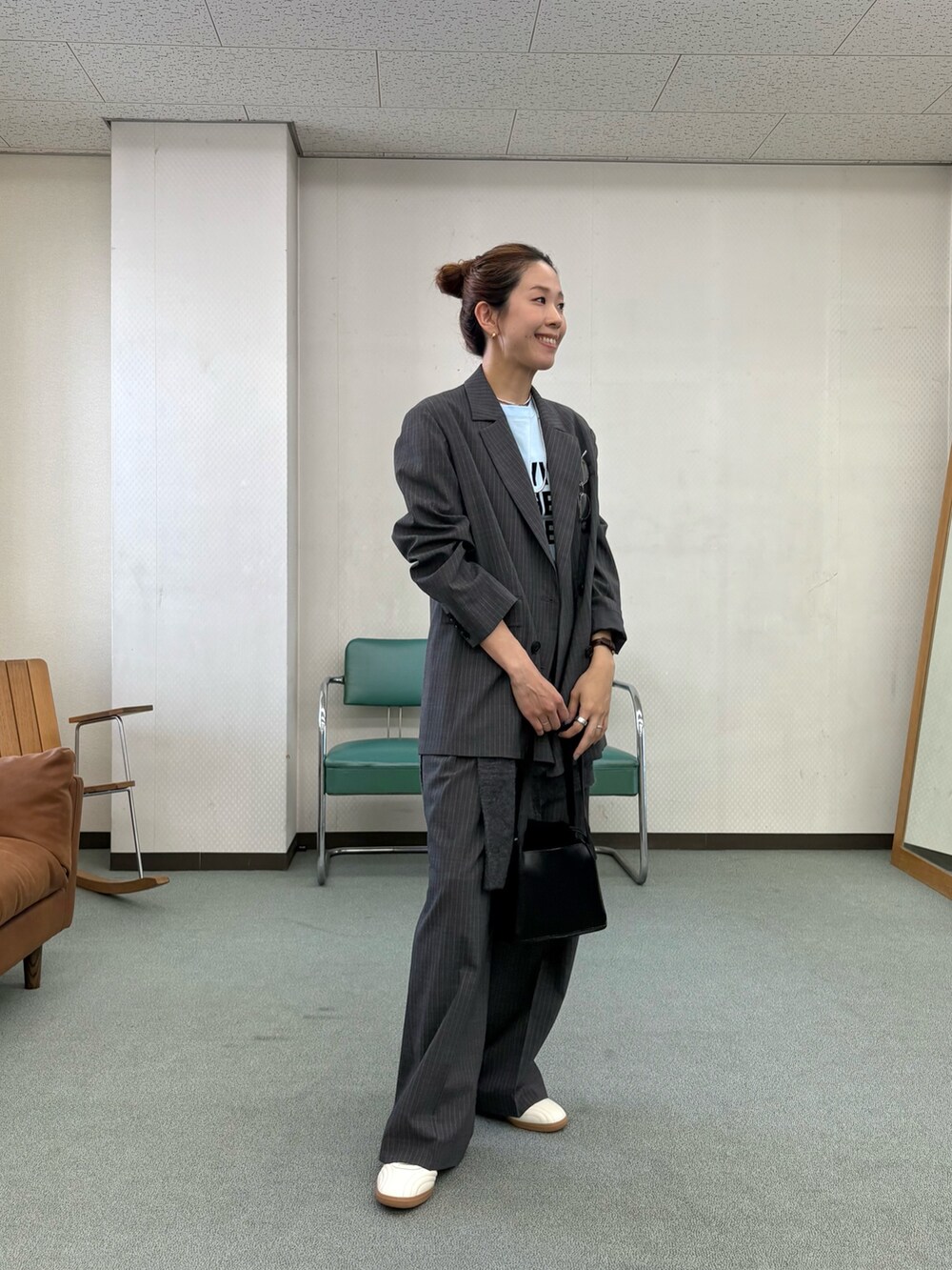 グレー系のその他パンツ、ホワイト系のスニーカー、ブラック系のハンドバッグを着用したレディースの秋コーディネートの5枚目の写真