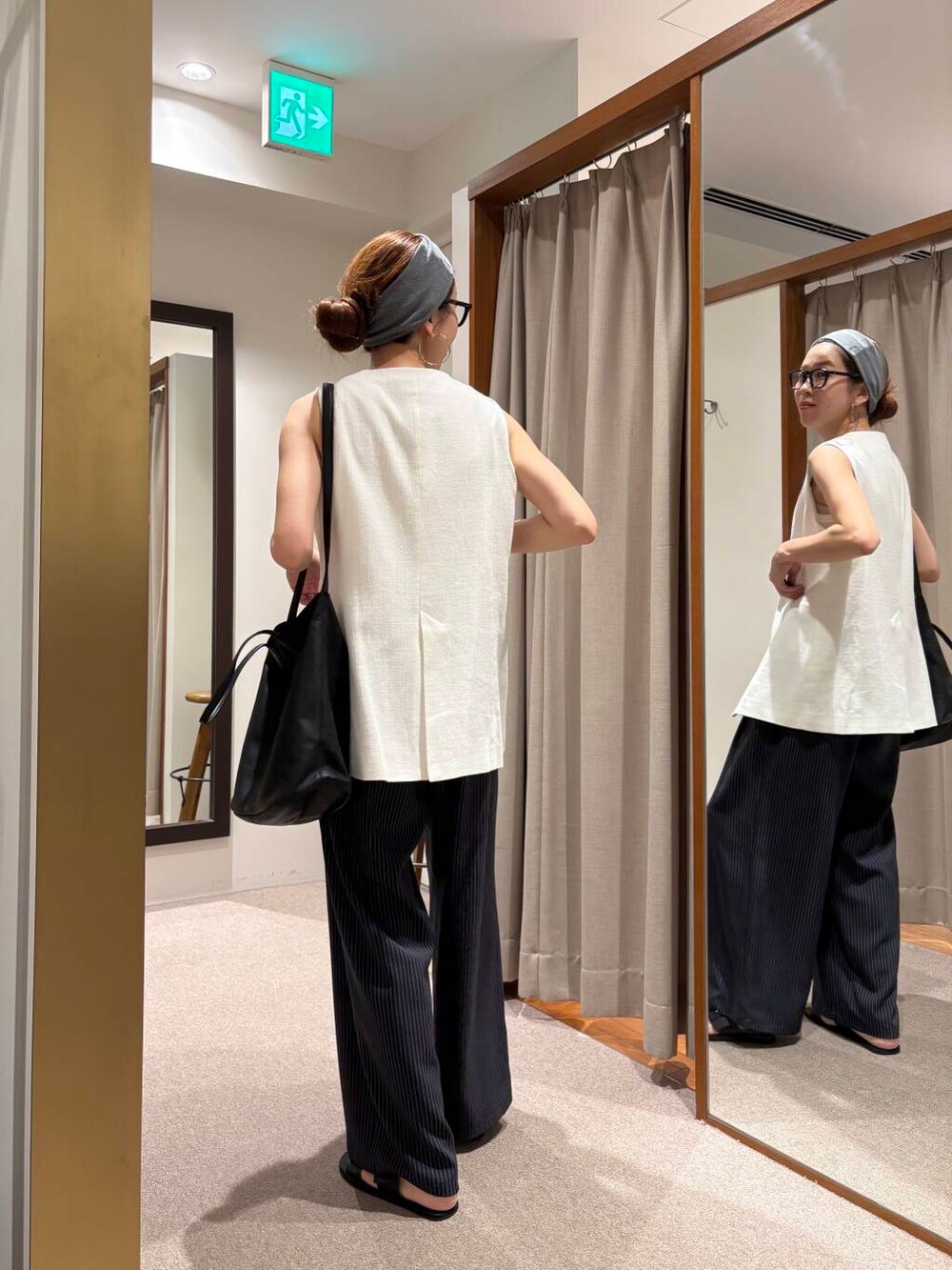 ブラック系のサンダル、ホワイト系のベスト、その他のその他パンツを着用したレディースの夏コーディネートの5枚目の写真