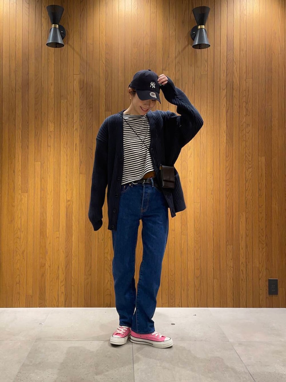 ブラック系のショルダーバッグ、ブルー系のカーディガン/ボレロ、ブラック系のベルトを着用したレディースの春コーディネートの2枚目の写真